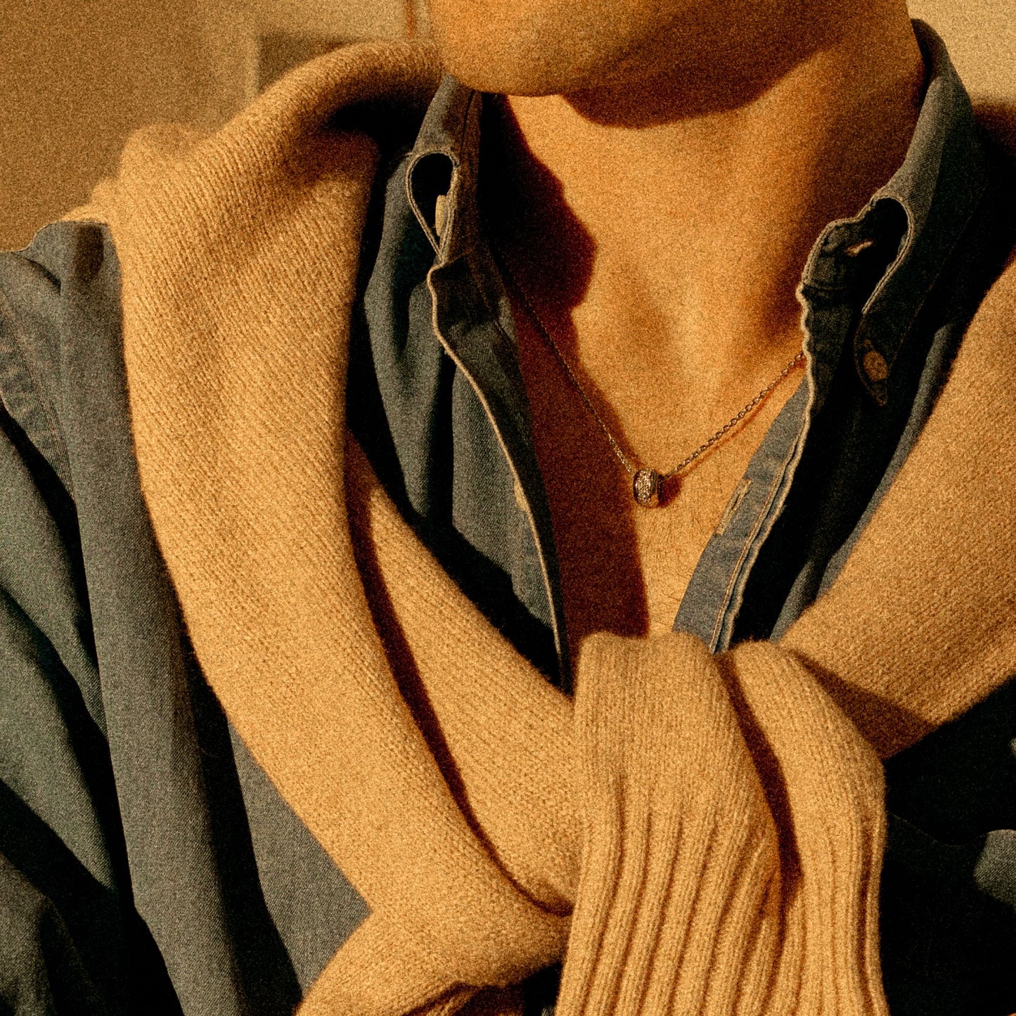 Person wearing 18k white gold ring pendant necklace with white diamonds in a warm-lit portrait
