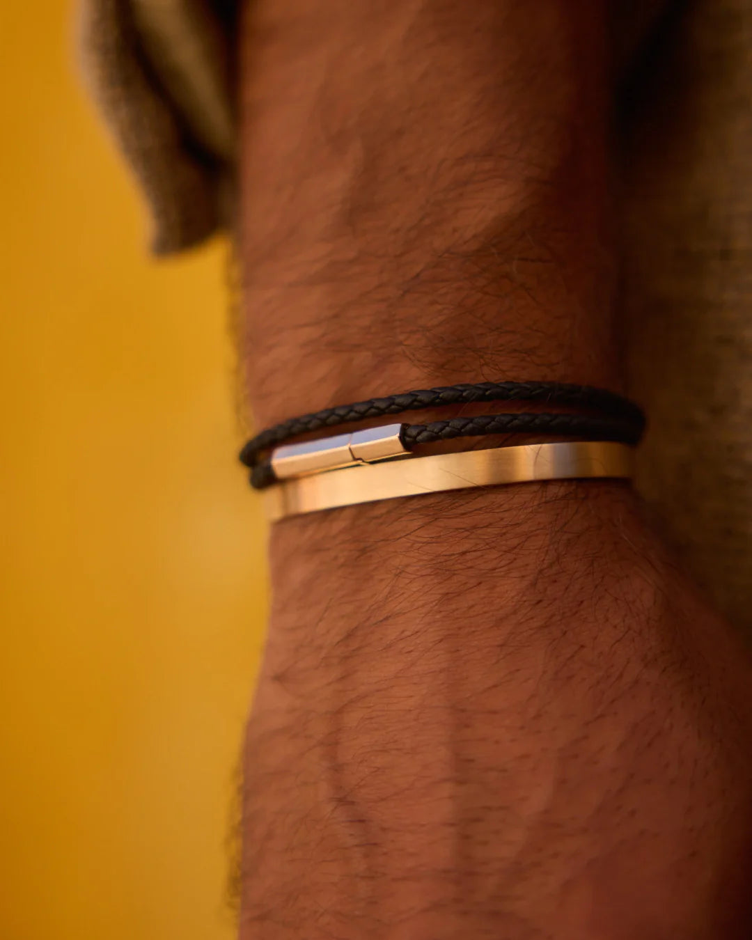 Prévaut luxury men’s bracelets; close-up wrist shot featuring 18k rose gold cuff and leather bracelet with hexagonal clasp