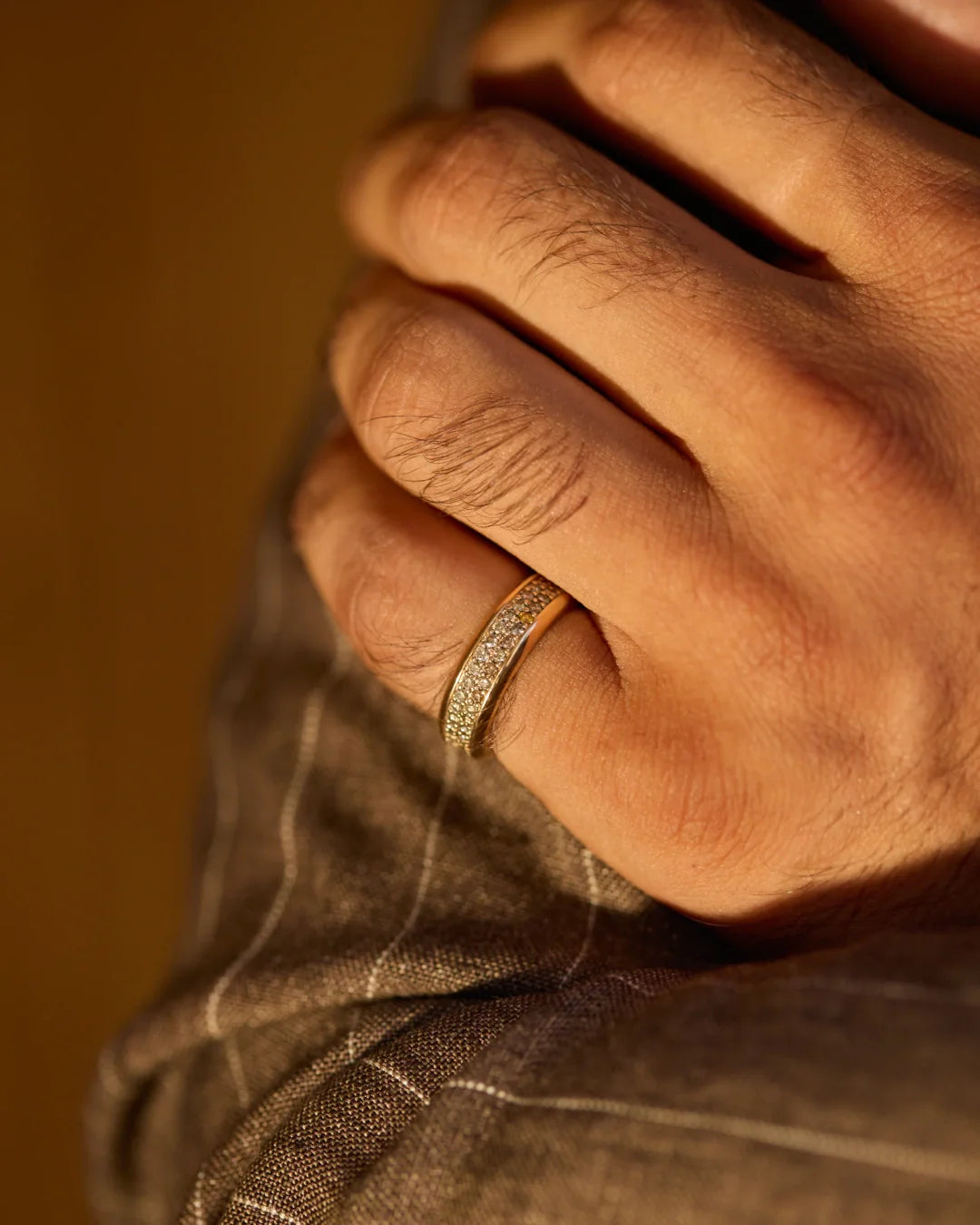 Prevaut men’s rings; close-up hand shot with 18k yellow gold diamond ring