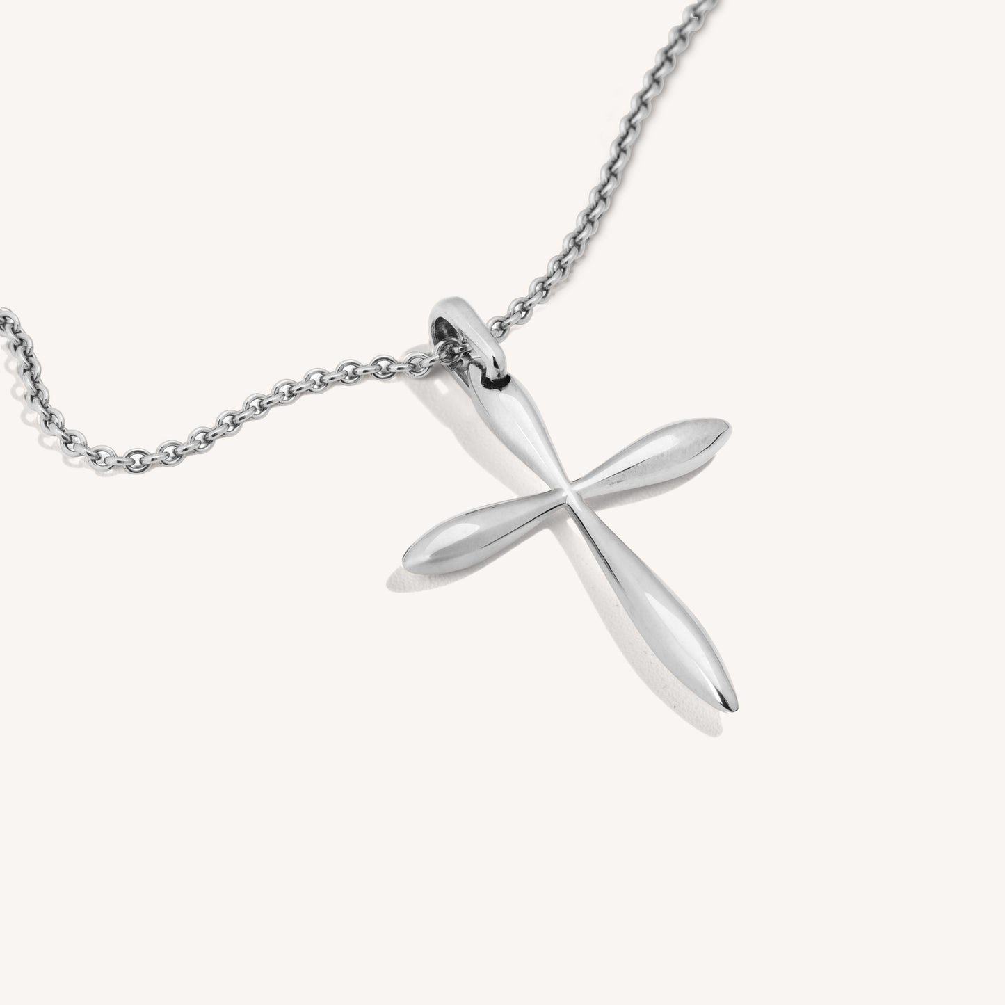 A polished 18-karat white gold cross pendant on a chain, showcasing smooth surfaces and sharp edges with a lustrous finish.