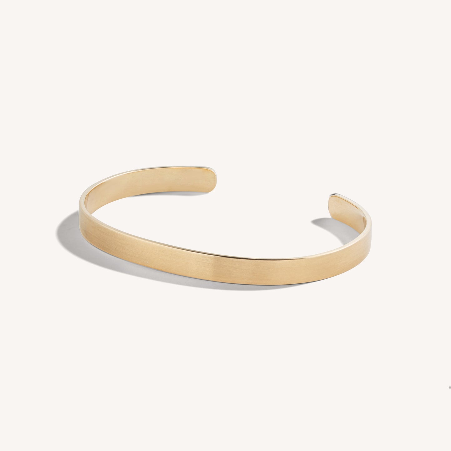 Men’s brushed 18k rose gold open cuff bracelet with rounded edges, on white background.