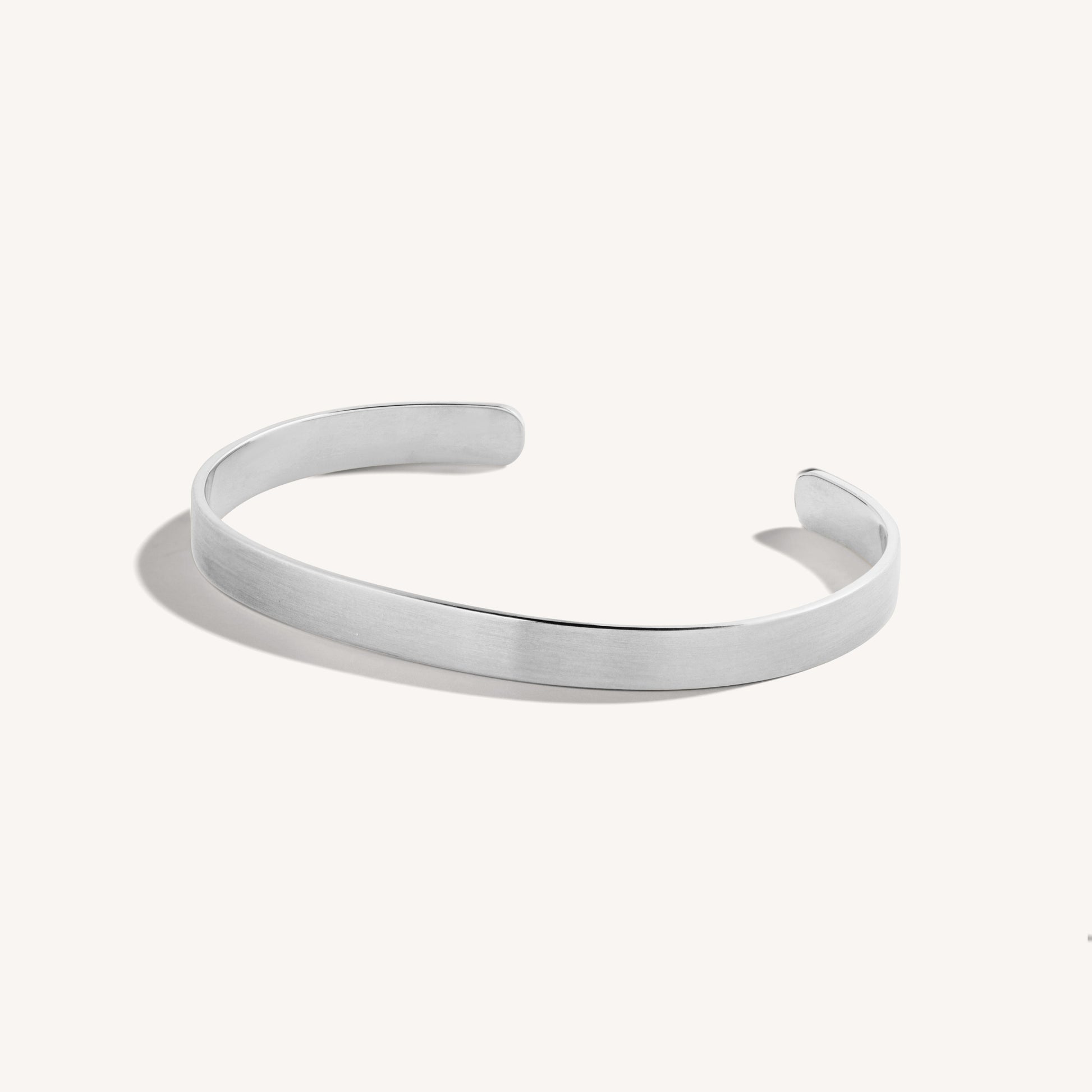 Men’s brushed 18k white gold open cuff bracelet with rounded edges, on white background.