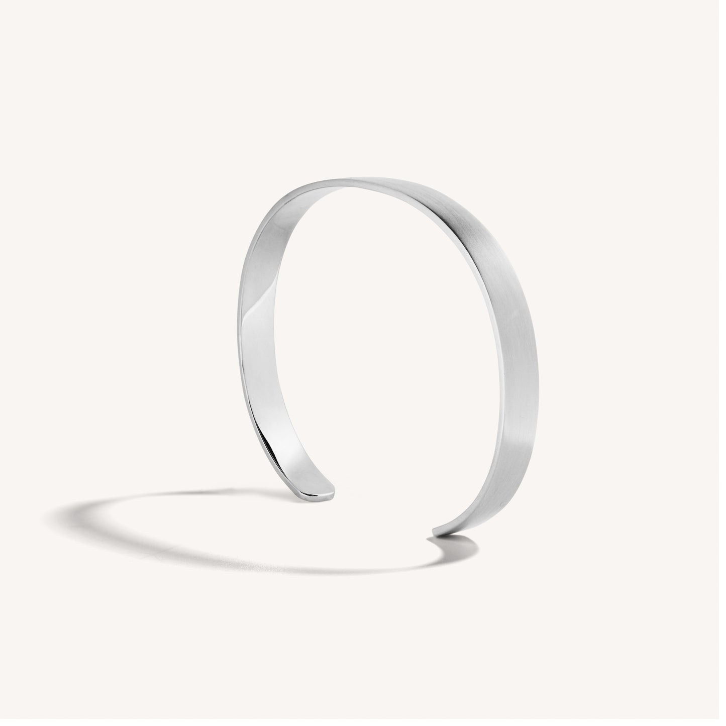 Men’s brushed 18k white gold open cuff bracelet with rounded edges, on white background.