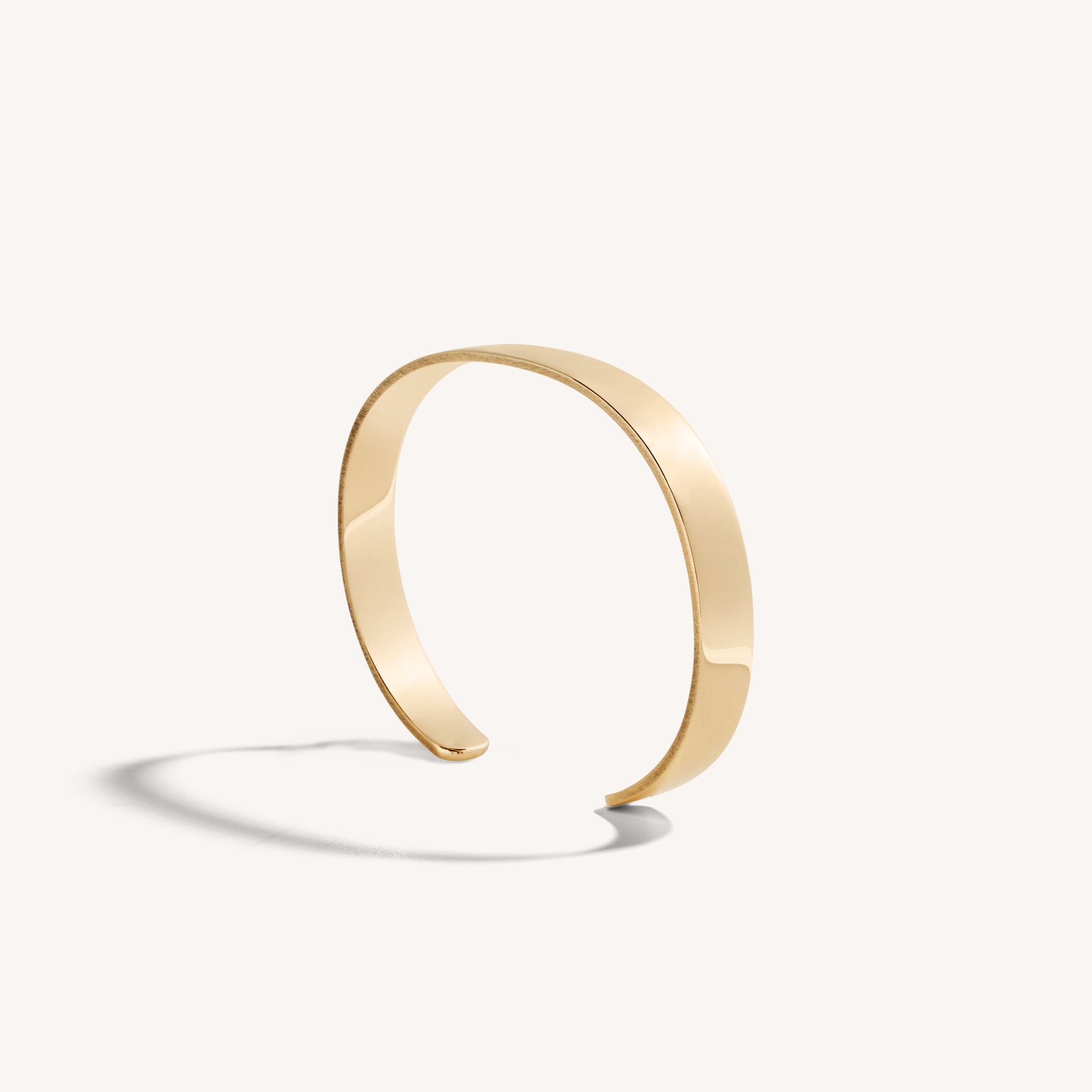 Men’s polished 18k rose gold open cuff bracelet with rounded edges, on white background.