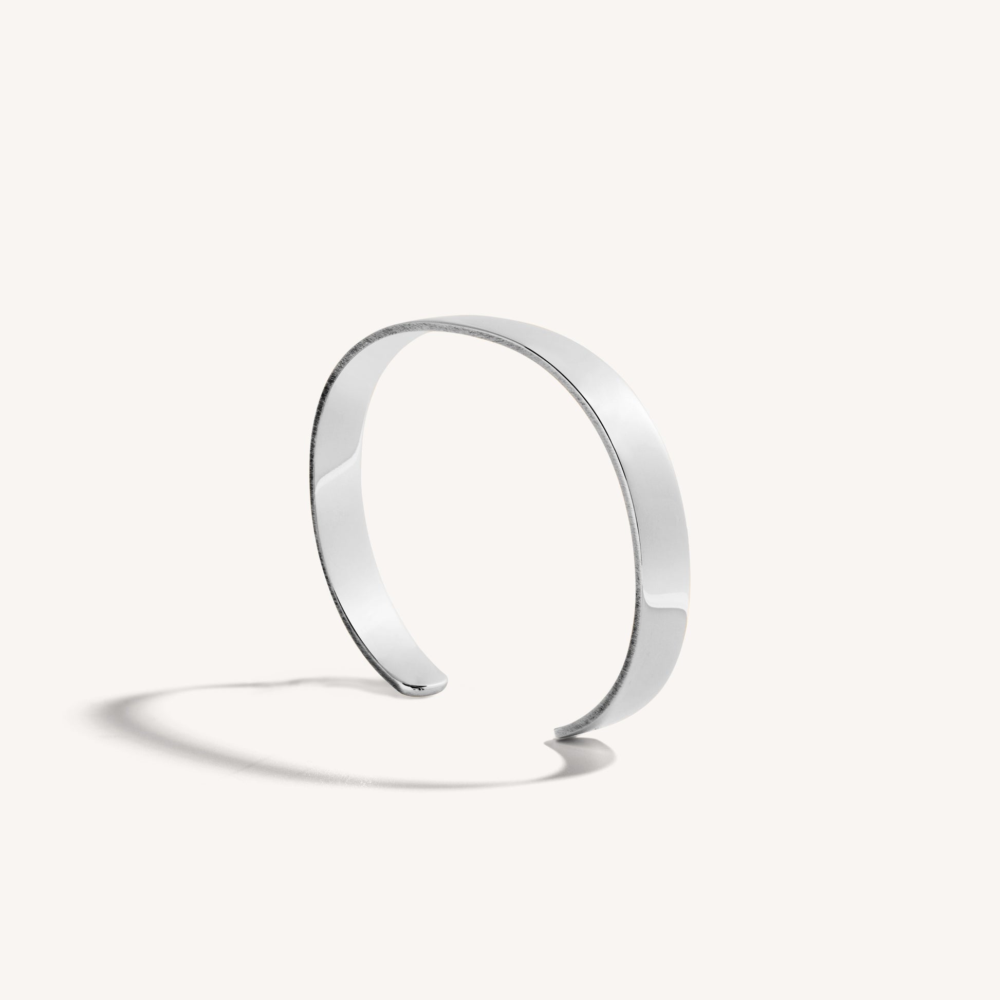 Men’s polished 18k white gold open cuff bracelet with rounded edges, on white background.