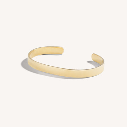 Men’s polished 18k yellow gold open cuff bracelet with rounded edges, on white background.