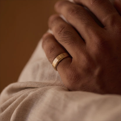 18k yellow gold beveled band ring worn on hand