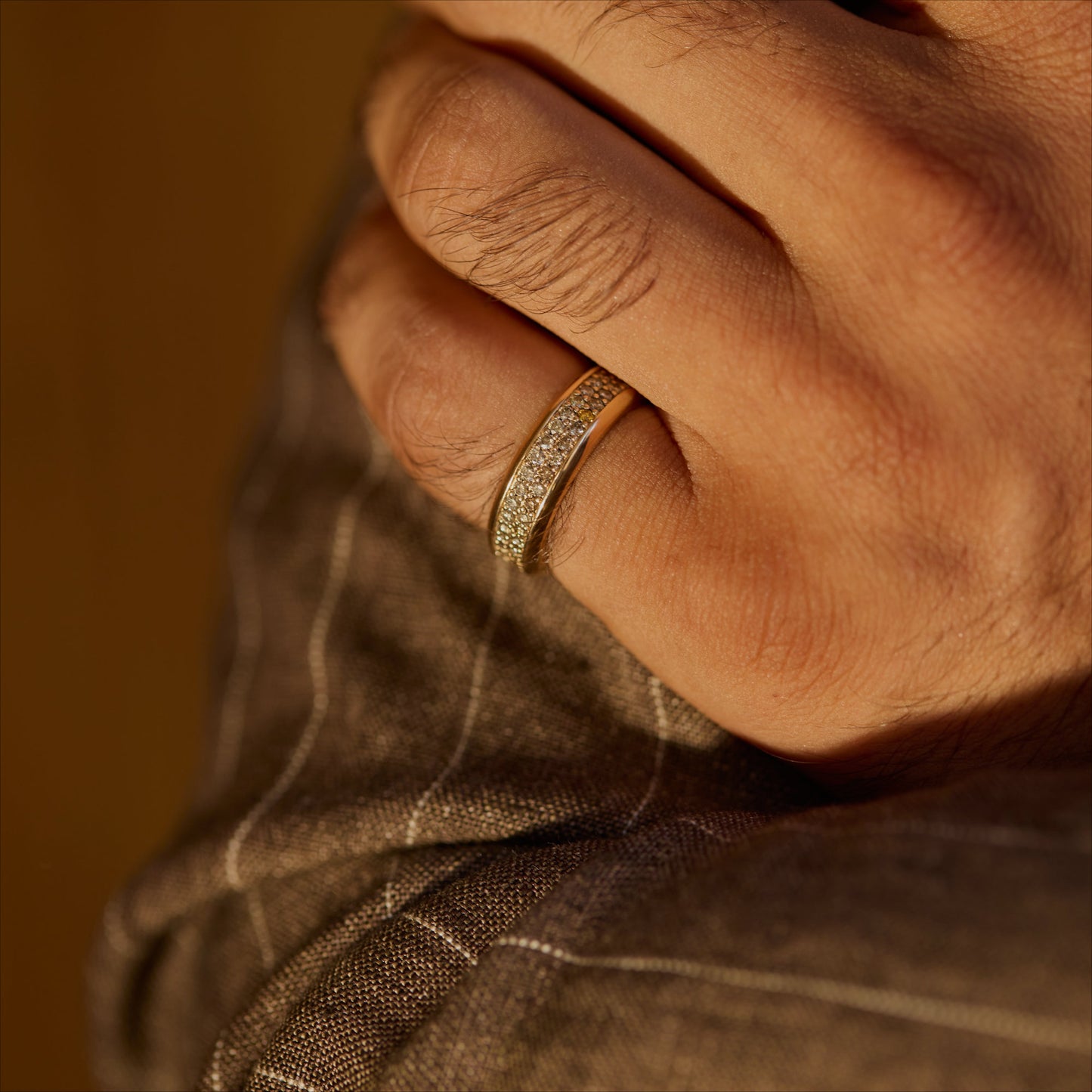 18k rose gold cognac-diamond pavé ring shown on a hand for scale in warm light.
