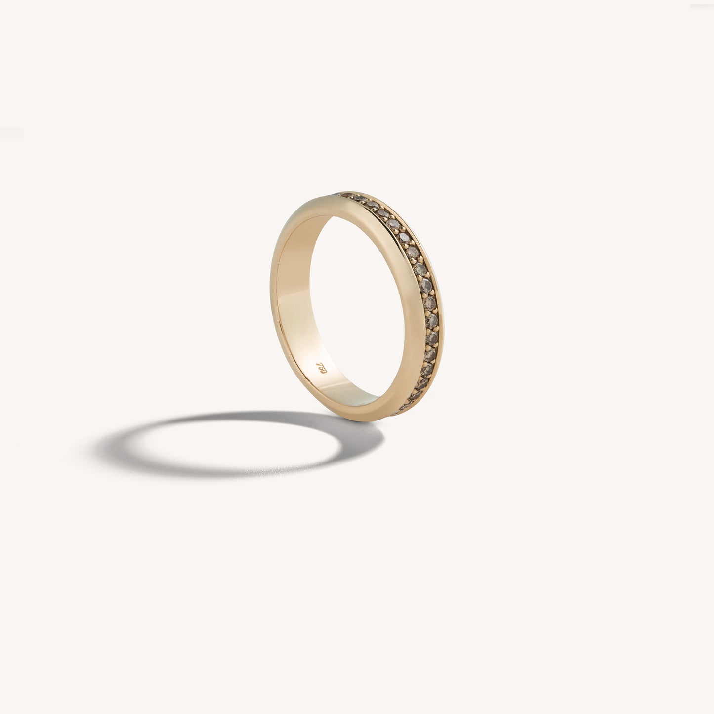 Slim 18k rose gold band with channel-set cognac diamonds around the circumference, hero angle.