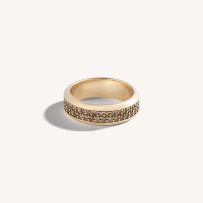 18k rose gold ring with a continuous row of channel-set cognac diamonds, flat-lay on neutral background.
